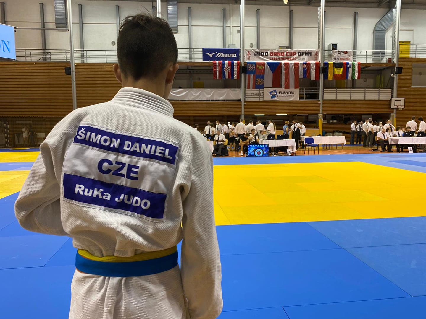 An athlete waiting before competition on an empty tatami