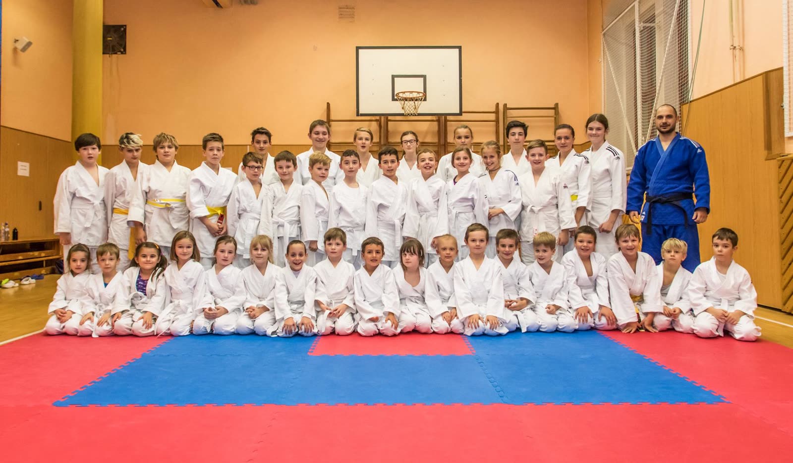 RuKa JUDO club group photo — dozens of children and coach Karel in blue judogi